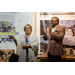 Treasurer James Cox and a women speaking to a group while standing in front of a wall of posters.