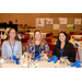 Three women sitting at a dining table.