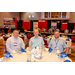 Three men sitting at a dining table with a buffet in the background.