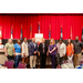 President Anthony Goodson, Jr. posing with eight other individuals in front of the stage with a podium and several flags.