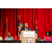 President Anthony Goodson, Jr. speaking at the podium while holding up a Housingopoly flyer.