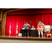 Two of the female contestants on one end of the stage trying to win the game being played.