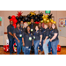 A group photo in front of a red, black, and gold balloon arch, with various colored and sized dice on the sides.