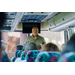 President Anthony Goodson, Jr. at the front of a bus speaking to the passengers sitting down in their seats.