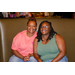 Two women sitting in a high backed booth.