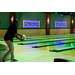 A gentleman mid swing of throwing a bowling ball down a lane.