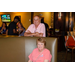 A woman sitting in a booth with a man standing behind her.