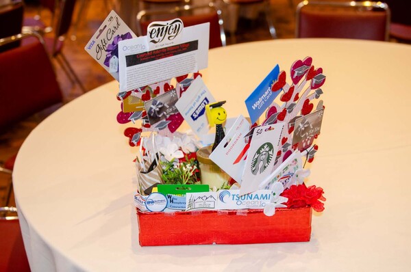  A front view of a red gift basket with several gift cards to various companies.