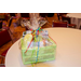 A green gift basket wrapped in clear plastic with a colorful bow.