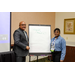 A woman and a man standing next to an easel note pad with the words Work Orders.