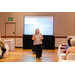 A woman standing in front of a projection screen.