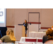 A female standing behind a podium giving a presentation.