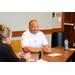 President Anthony Goodson, Jr. wearing a white shirt and listening to someone speaking off camera.