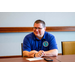 A gentleman in a Tennessee Valley Regional Housing Authority polo smiling while leaning on a table.