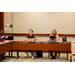 Two women sitting at a table with various note taking tool in front of them.