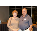 A woman and a man standing between small round tables.