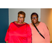 A woman in a bright pink shirt and a woman in a baby pink shirt.