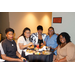 Five women sitting and eating around a small round table.