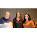 Two women and a man taking a group photo.