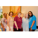 Five woman standing in front of a painting taking a group photo.