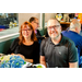 A man and a woman wearing black shirts sitting at a small dining table.