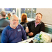 Two gentleman sitting at a dining table smiling for the camera.