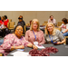 Three women leaning in for a group photo around a table.