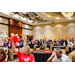 Everyone in a room holding up various colored pom poms.