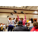 People with black pom poms standing and cheering.