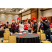 A large group of individuals holding up red pom poms.