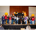 A group photo taken on the stage with the balloon arches in the background.