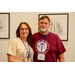 A woman in a beige faith shirt standing next to a man in a red Medieval Times shirt.