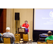 A man giving a presentation from behind a podium that says Renaissance, Montgomery Hotel and Spa at the Convention Center.