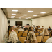 A room full of people sitting in chairs to listen to a speech.