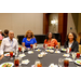 Four individuals sitting around a dining table filled with food.