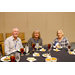 A man and two women sitting together around a dining table.