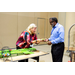 A woman handing out a Bingo card to an individual.