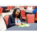 A woman smiling while she looks at her Bingo cards.