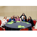 Seven women sitting and standing around a table.