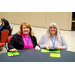 Two women with Bingo cards smiling for the camera.