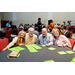 Four individuals playing Bingo with several cards in front of them.