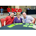 Three individuals leaning in for a group photo while they play Bingo.