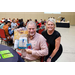 A man holding up a gift bag and gift card while posing with a woman.