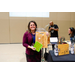 A woman holding a cutting board that says Kitchen, the best times are always when friends gather around.