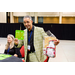 A gentleman in a green plaid suit holding up a Bingo card and a gift bag.