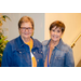 Two women in jean jackets smiling for the camera.