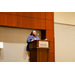 A woman in a blue blazer speaking at a podium that says Renaissance Hotel and Spa at the Convention Center.