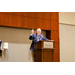 A man speaking at a podium while also gesturing with his hands.