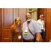 A man and a woman standing in an entryway smiling for the camera.