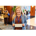 A woman smiling for the camera while she holds a check in front of herself.